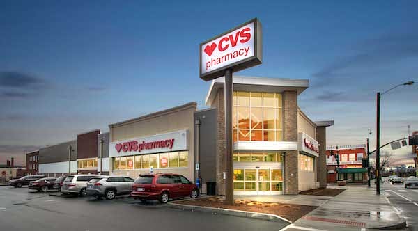 Exterior view of a CVS Springfield MA pharmacy store at twilight with a large red and white sign, parked cars, and a clear sky.
